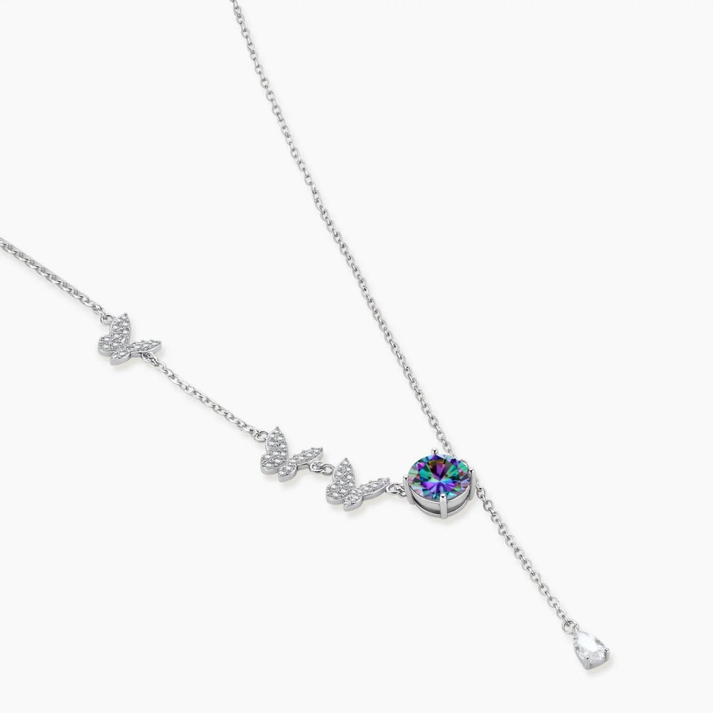 Sterling silver jewelry set with rainbow moissanite stones in clover and butterfly designs on cream background