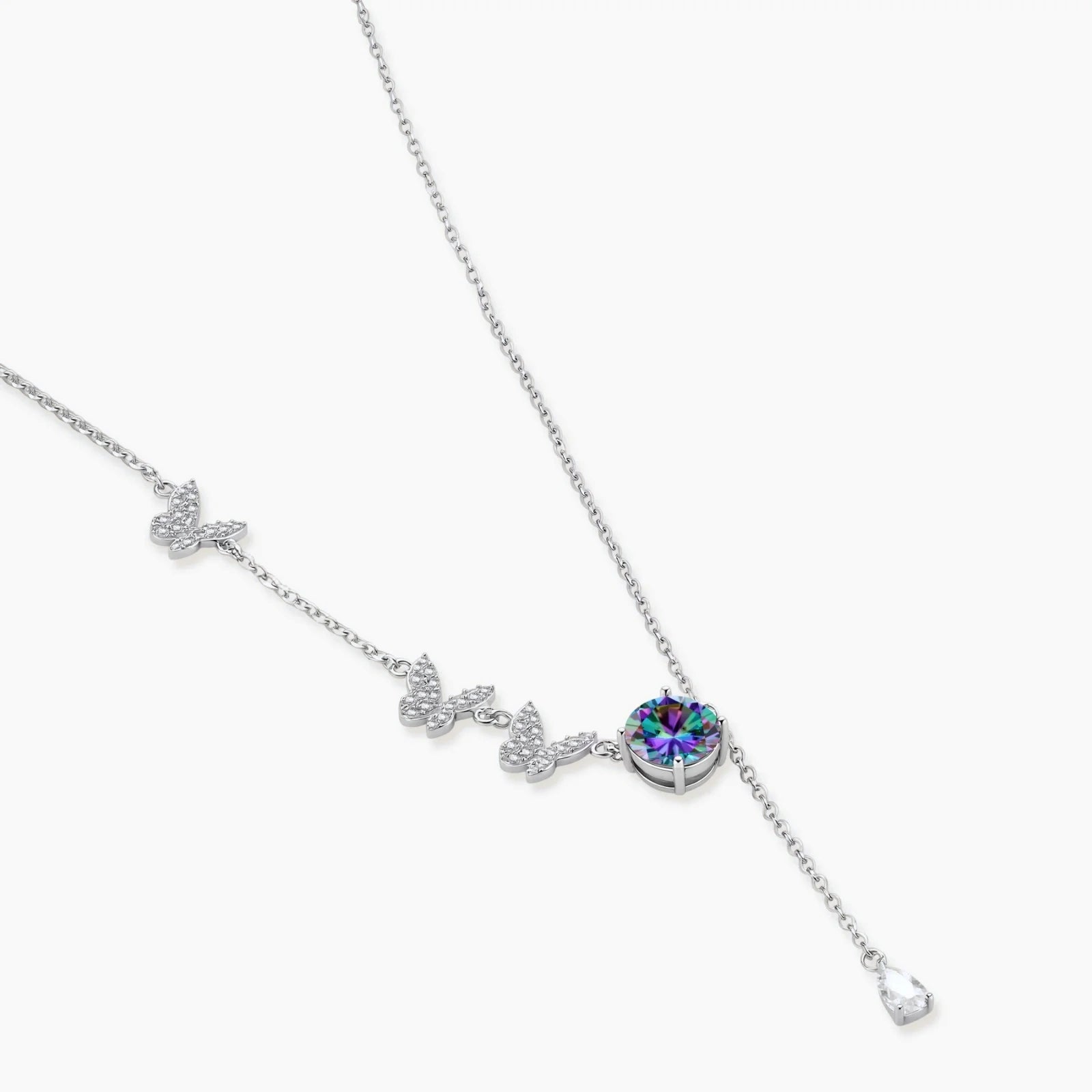 Sterling silver jewelry set with rainbow moissanite stones in clover and butterfly designs on cream background