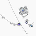 Sterling silver jewelry set with rainbow moissanite stones in clover and butterfly designs on cream background