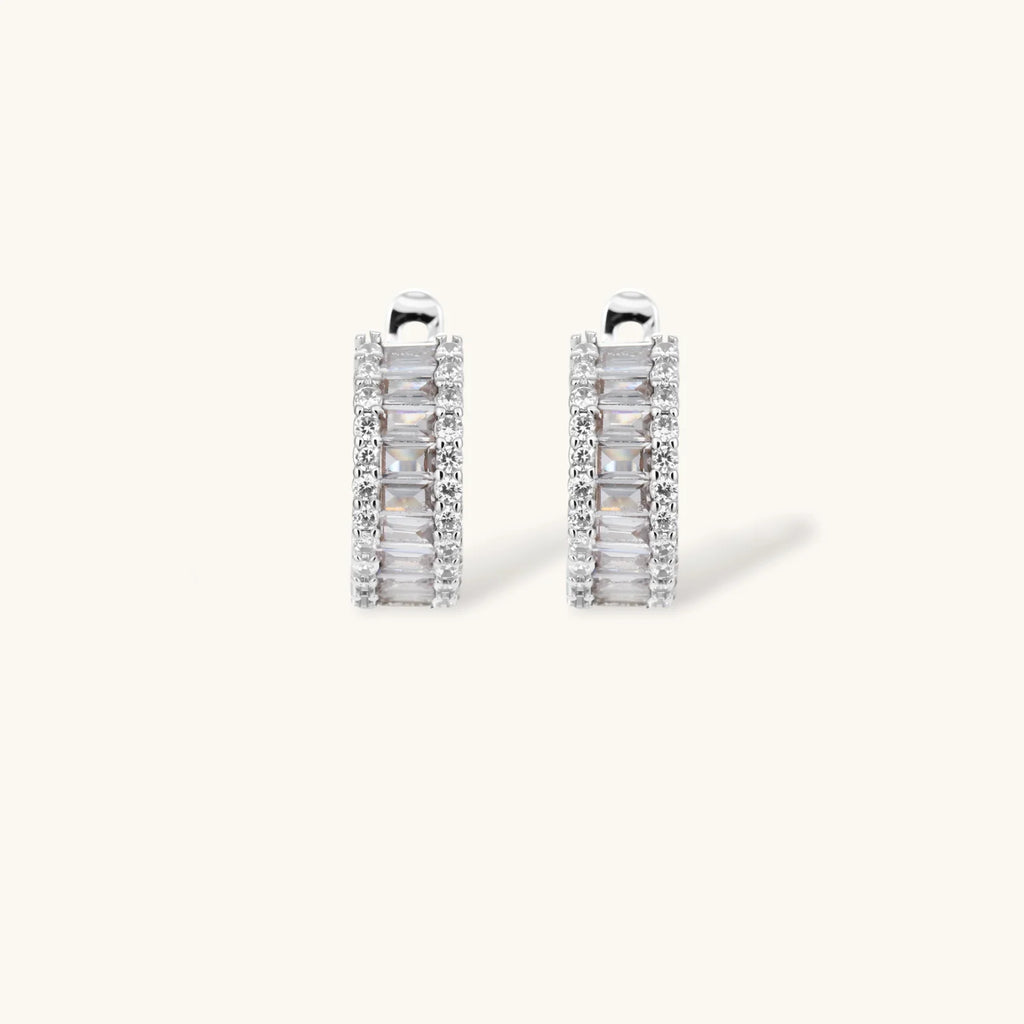 White gold plated necklace with vertical cubic zirconia pendant and matching hoop earrings on neutral background
