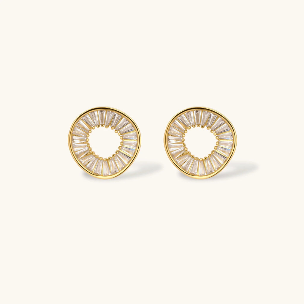 Gold-plated necklace and earring set with circular CZ crystal pendants featuring radial design on cream background