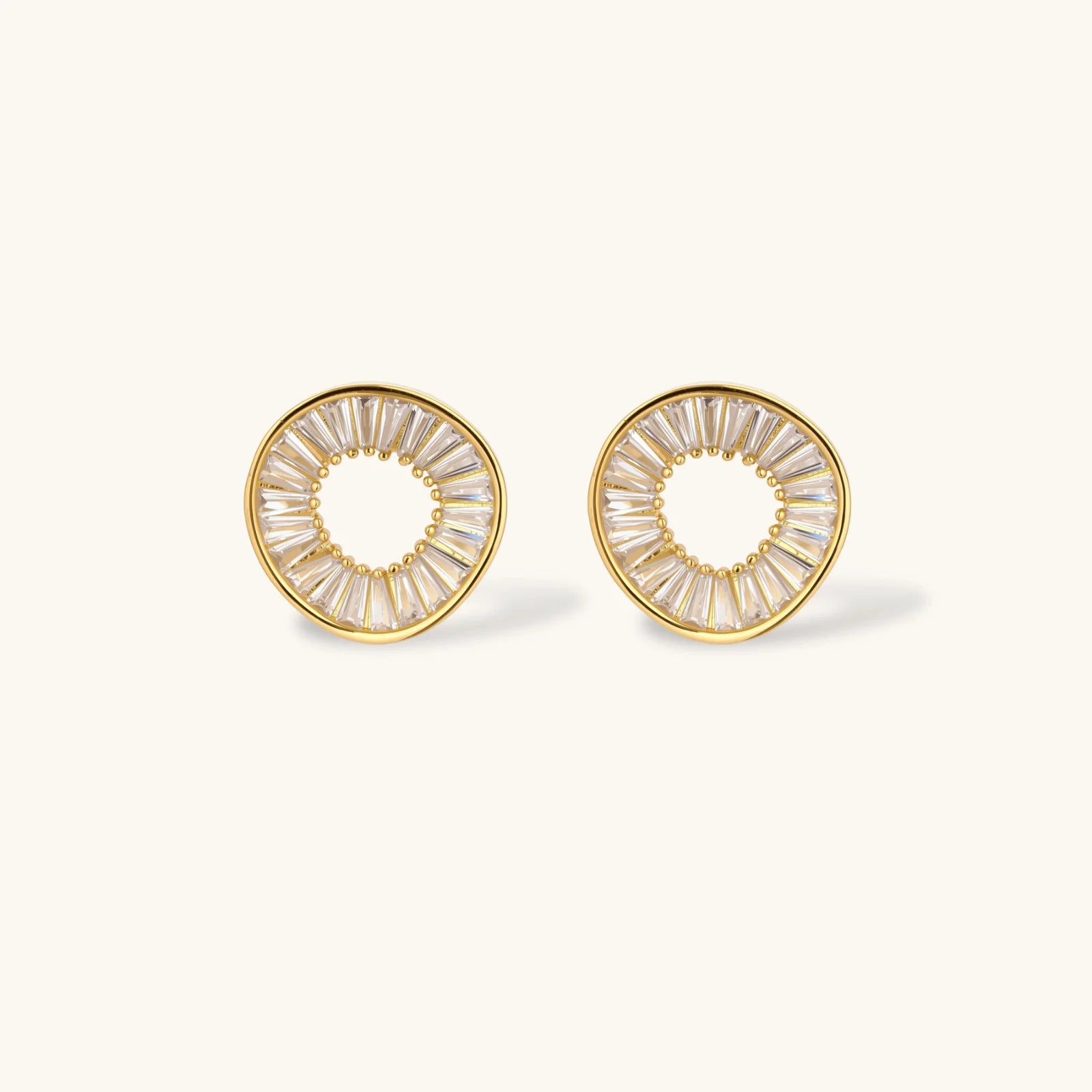 Gold-plated necklace and earring set with circular CZ crystal pendants featuring radial design on cream background