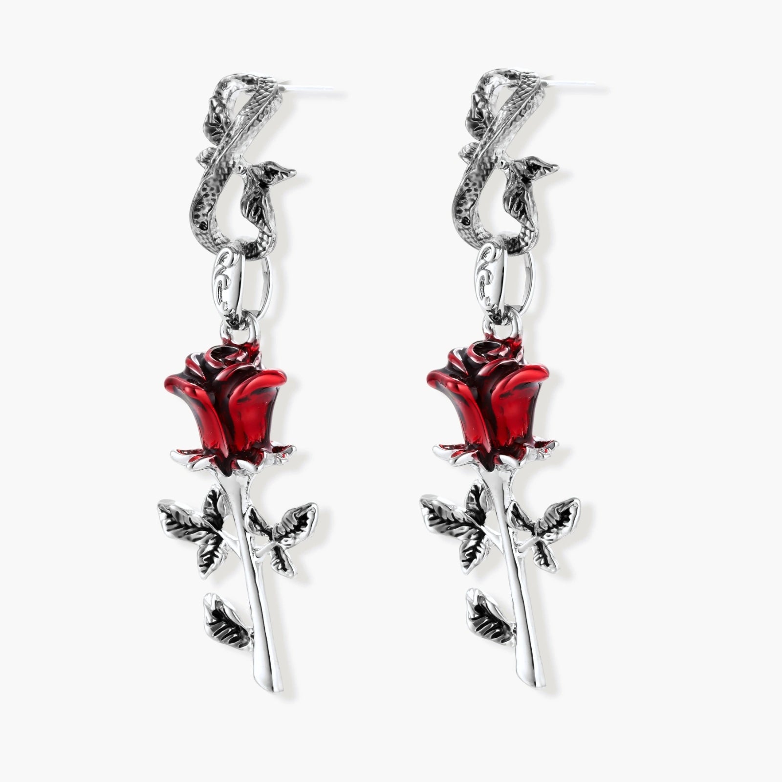 Gothic dangle earrings featuring silver serpent hooks with red enamel roses and metallic stems on white background.