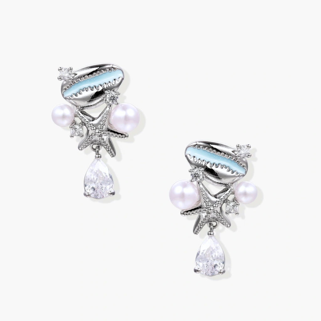 Ocean-themed drop earrings with blue enamel shells, white pearls, starfish charms and crystal teardrops on white background.