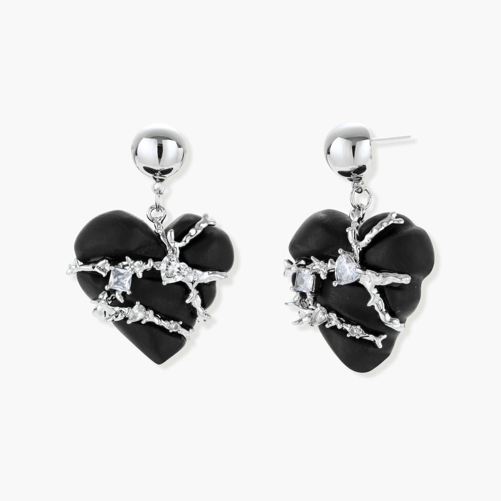 Dark ebony wood heart charms wrapped in intricate silver chains with crystal accents, shown as matching earrings and necklace set.