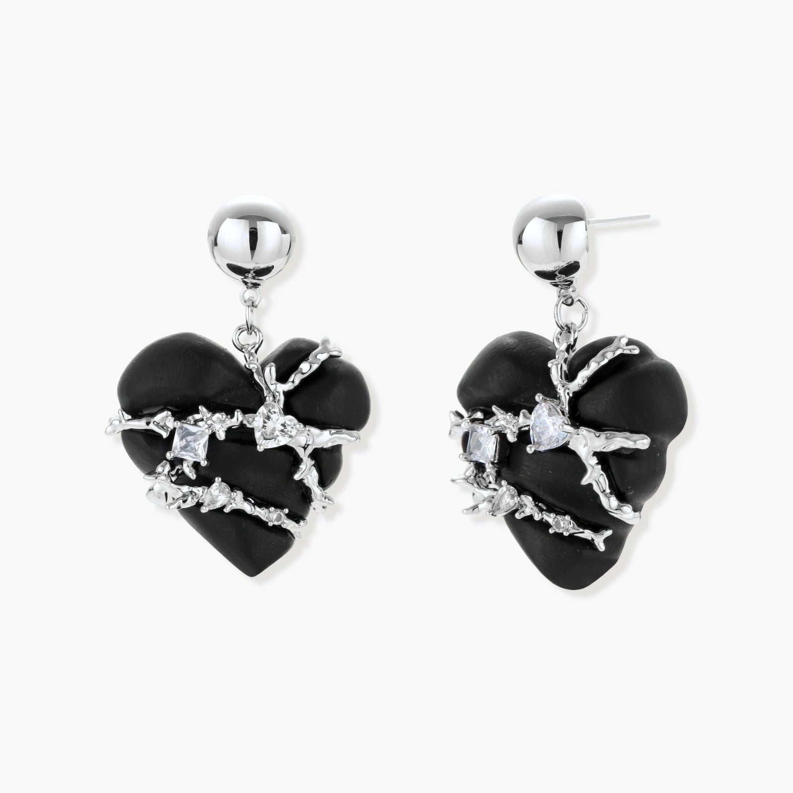 Dark ebony wood heart charms wrapped in intricate silver chains with crystal accents, shown as matching earrings and necklace set.