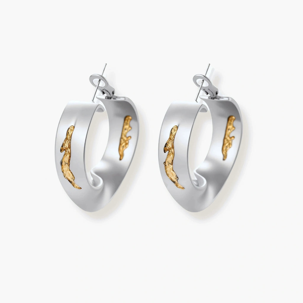 Artistic jewelry set featuring curved silver pendant with gold veining on black cord plus matching asymmetrical hoop earrings