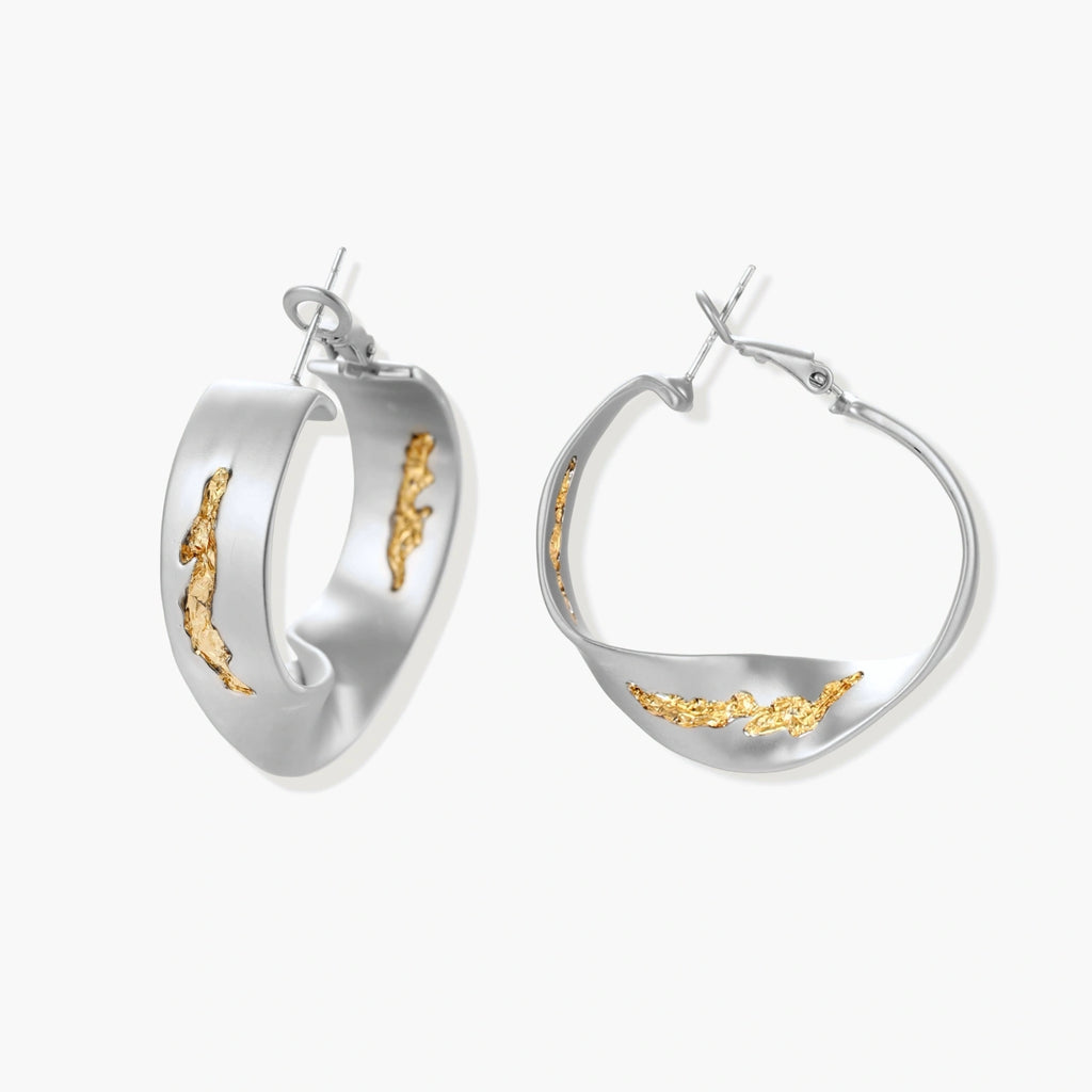 Artistic jewelry set featuring curved silver pendant with gold veining on black cord plus matching asymmetrical hoop earrings
