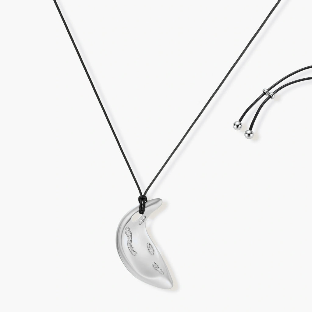 Adjustable crescent moon pendant necklace in gold and silver eco-zinc alloy with decorative engravings on black cord