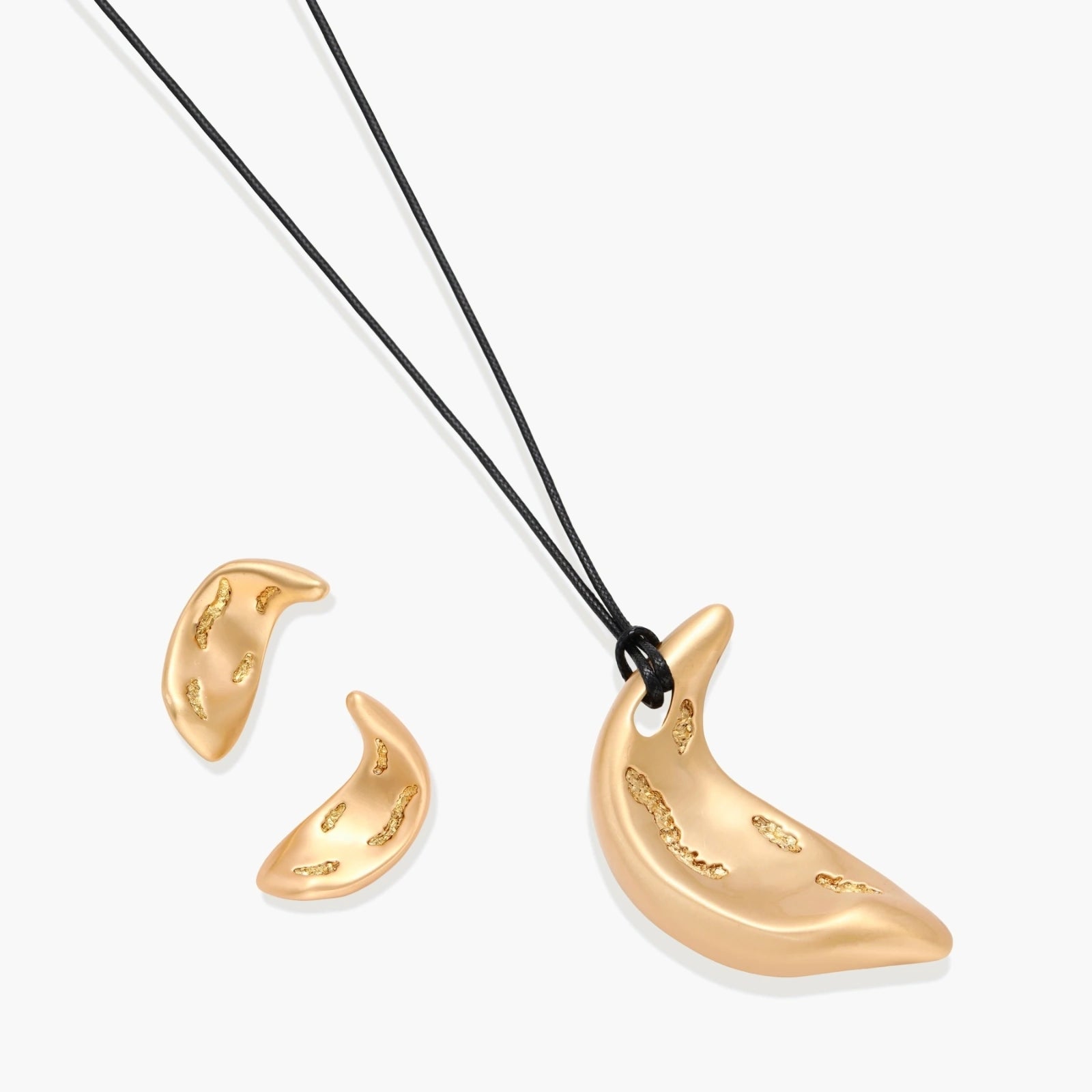 Gold-toned crescent moon pendant with textured surface on black adjustable cord, displayed with matching crescent earrings