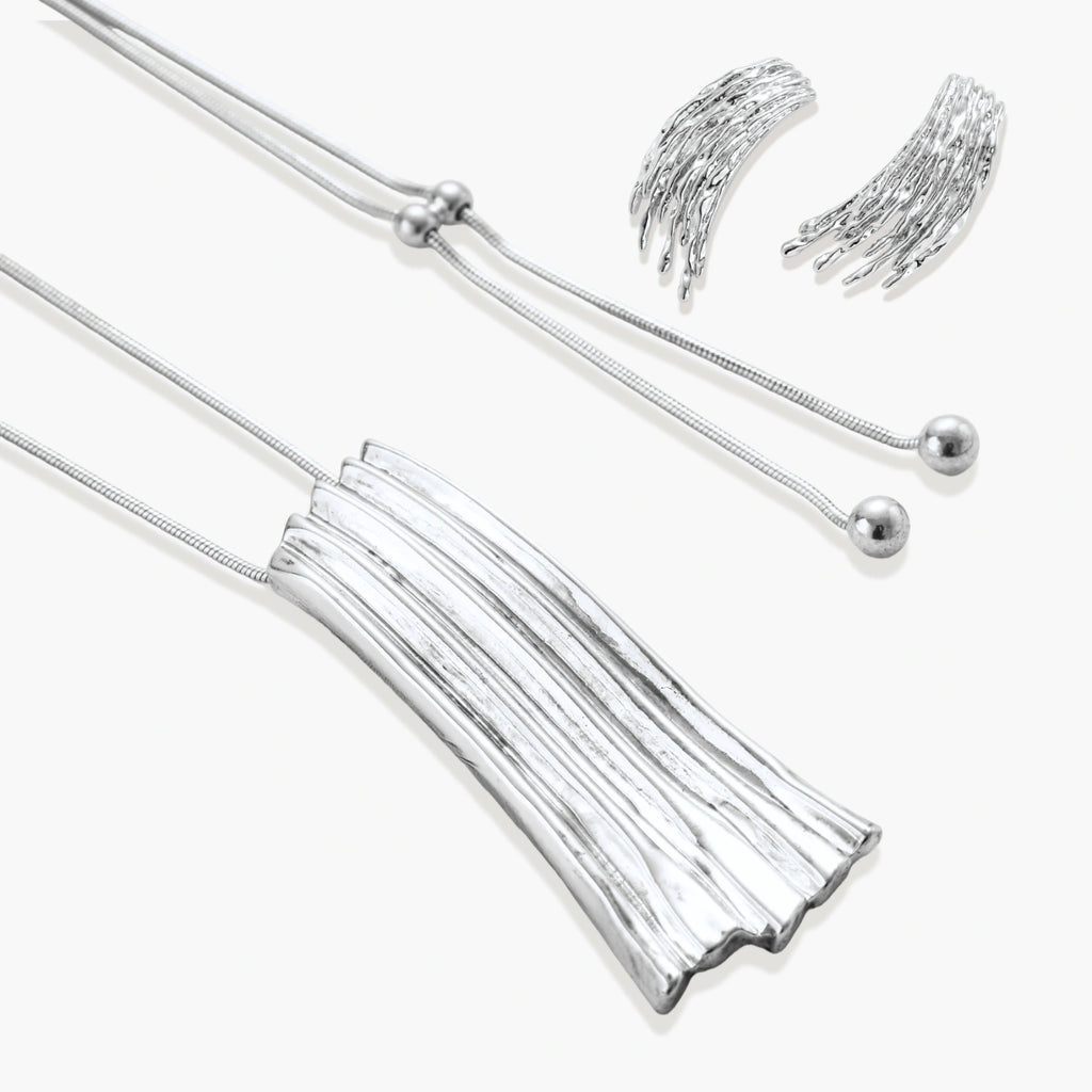 Layered metallic wing-shaped pendant and matching earrings with feathered texture in silver and gold finishes