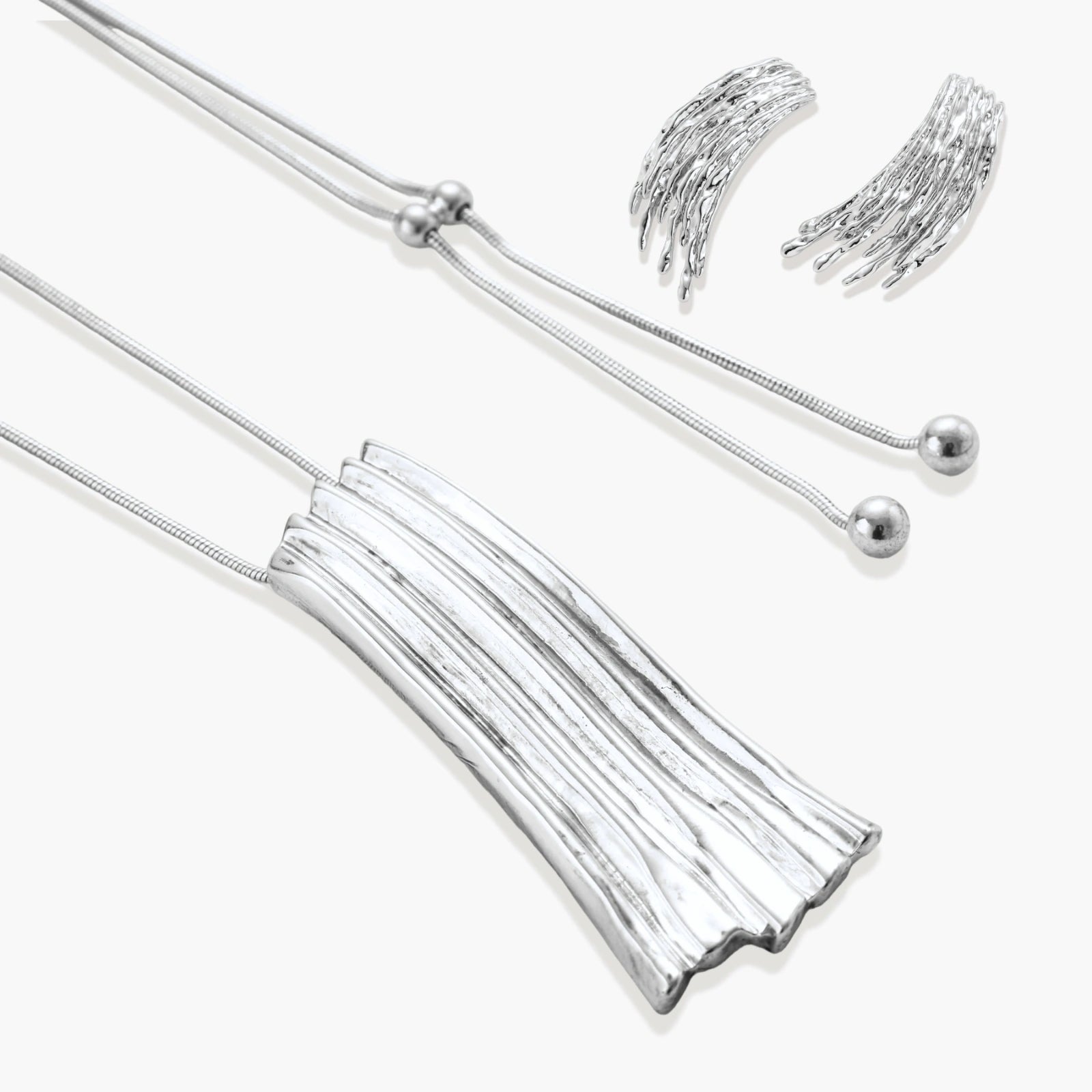 Layered metallic wing-shaped pendant and matching earrings with feathered texture in silver and gold finishes