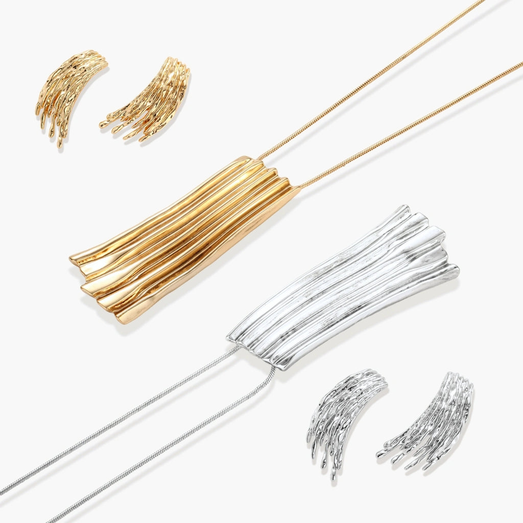 Layered metallic wing-shaped pendant and matching earrings with feathered texture in silver and gold finishes
