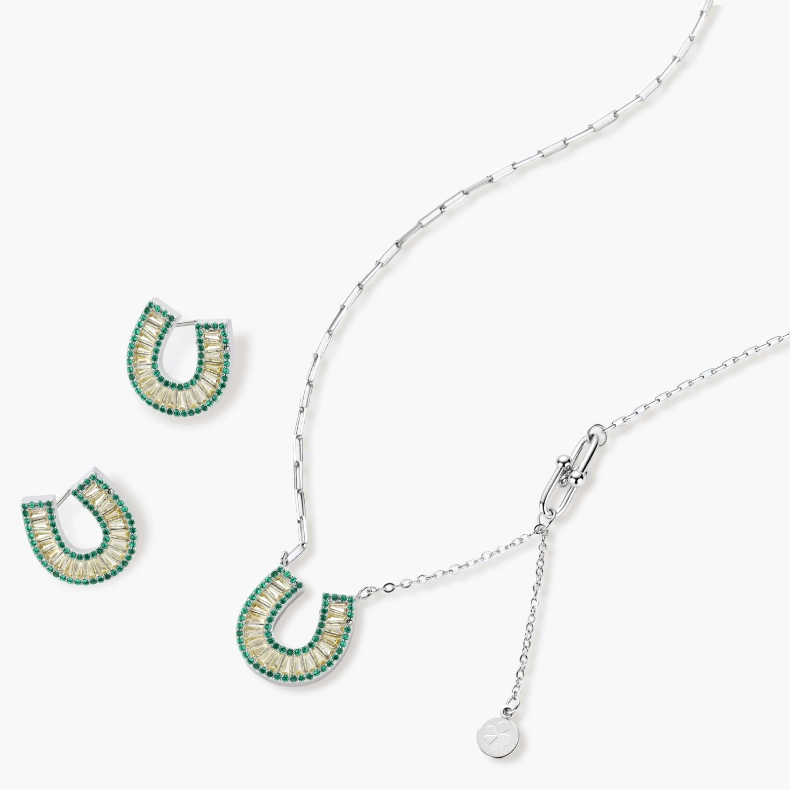 Geometric horseshoe-shaped jewelry set with radiating white zirconia center and jade-green border stones on white background.