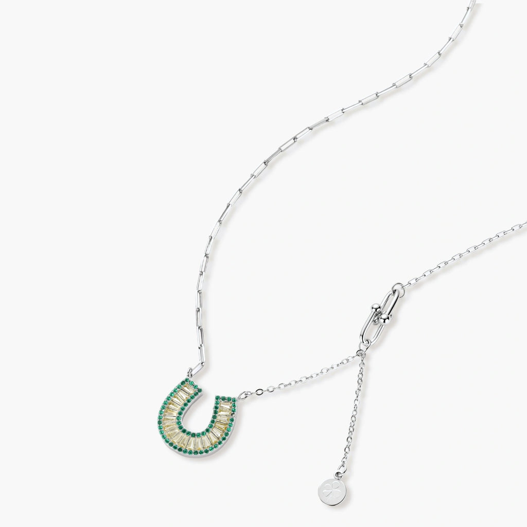 Geometric horseshoe-shaped jewelry set with radiating white zirconia center and jade-green border stones on white background.