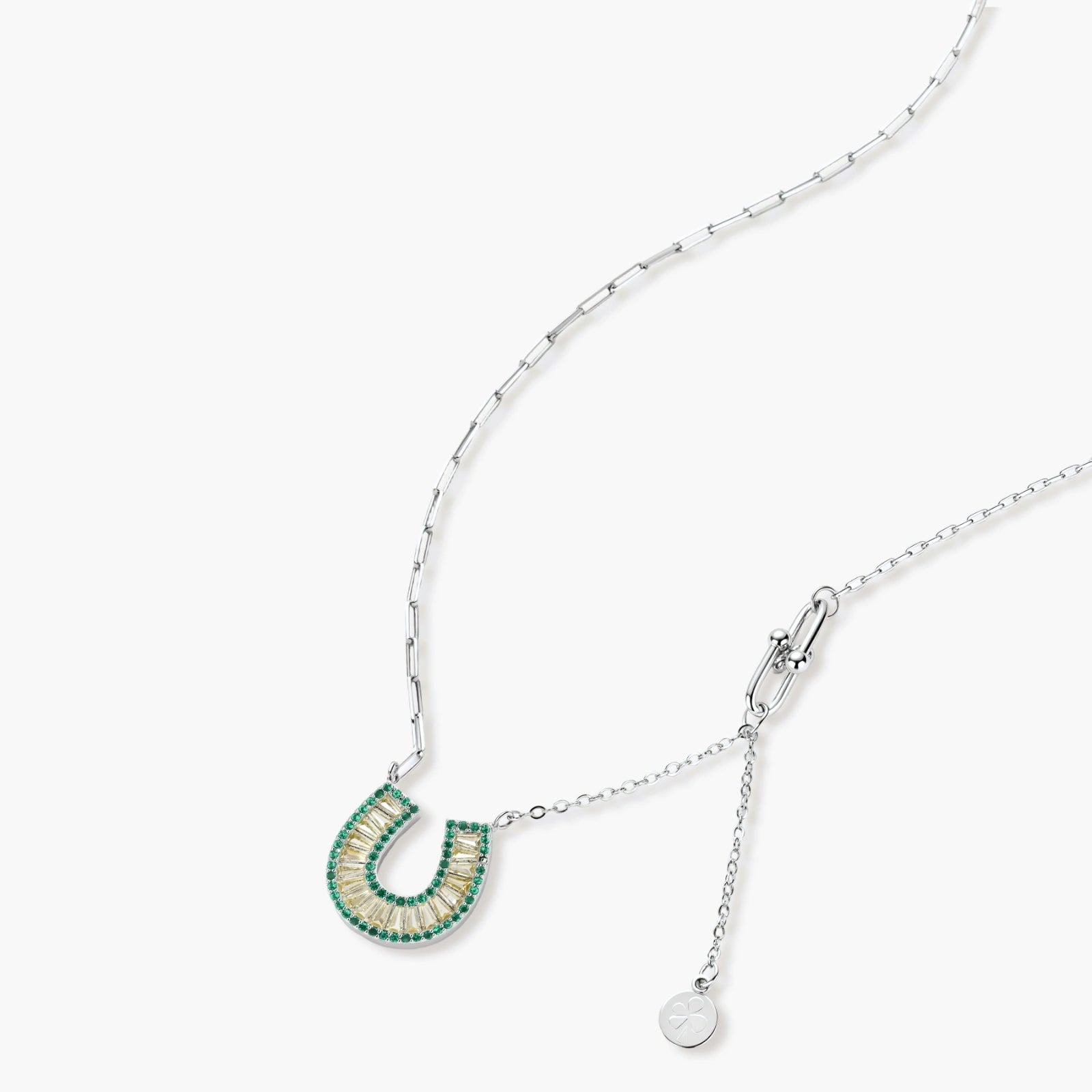 Geometric horseshoe-shaped jewelry set with radiating white zirconia center and jade-green border stones on white background.