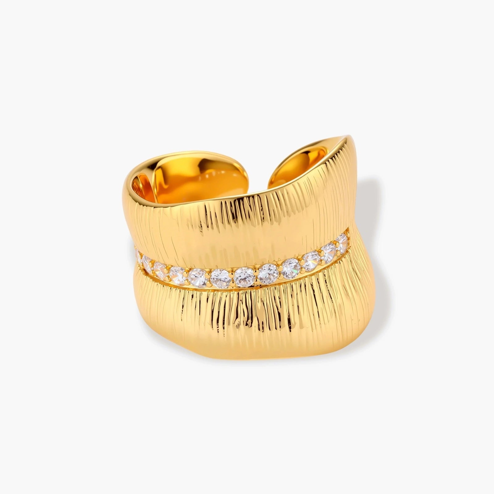 Adjustable gold-plated cuff ring with parallel ridged texture and diagonal row of sparkling zirconia stones on white background.
